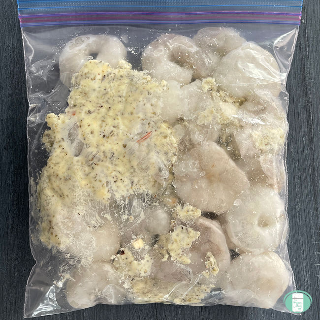 clear bag with raw shrimp and butter in it