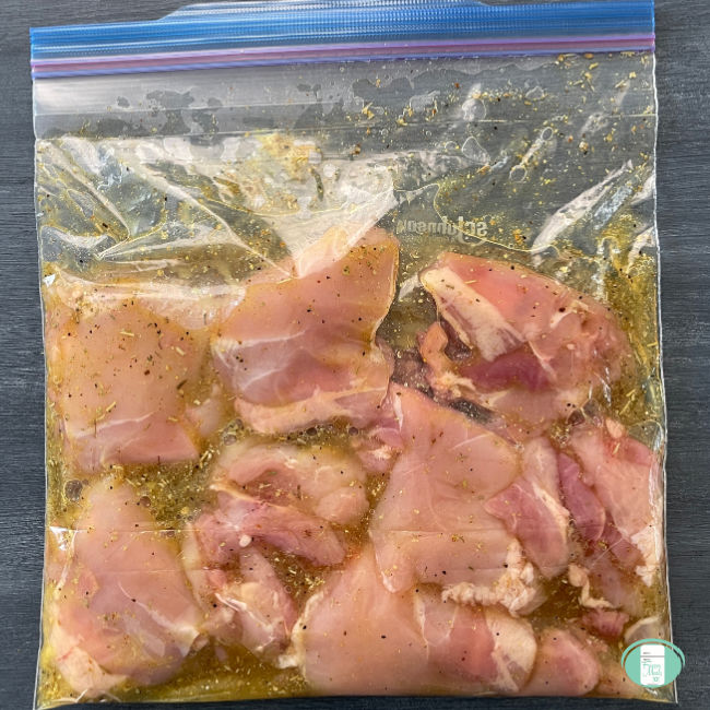 clear bag with raw chicken in an almost clear yellow marinade