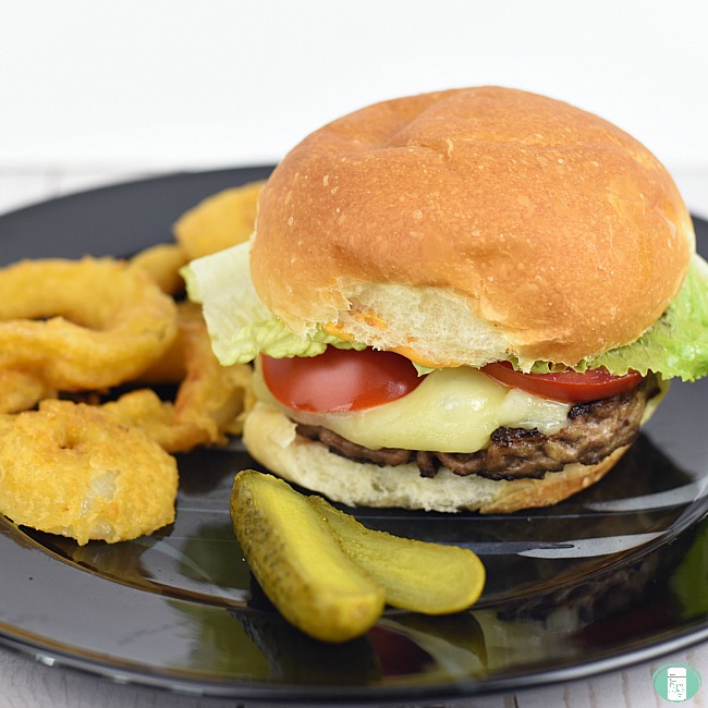 close up of blue cheese hamburgers with pickles and onion rings