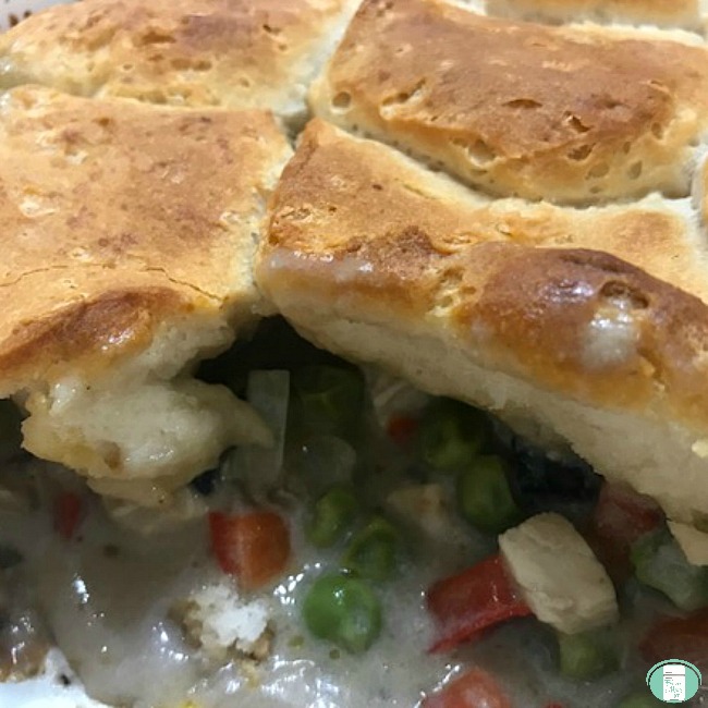 close up of chicken pot pie filling under biscuit topper