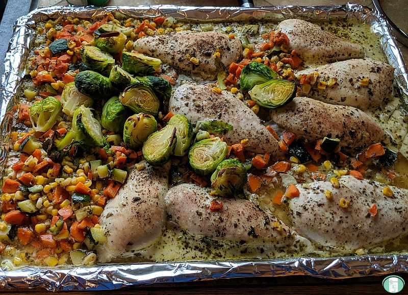 pesto chicken and vegetables on a baking sheet, ready to serve