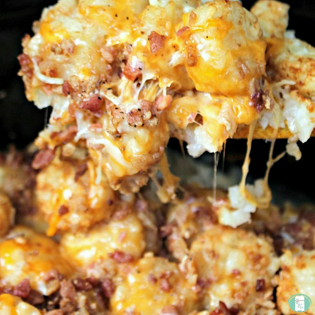 close up of a scoop of tater tot casserole with strings of cheese