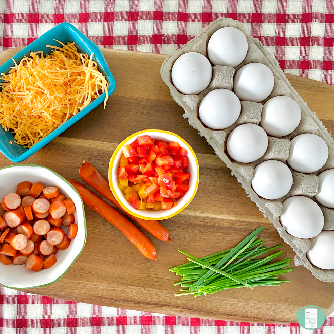 ingredients for scrambled egg bites; cheese, tomatoes, eggs, meat and green onions