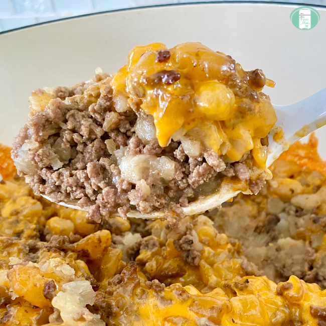 close up of a spoon scooping out some easy beef hash with cheese melted on top