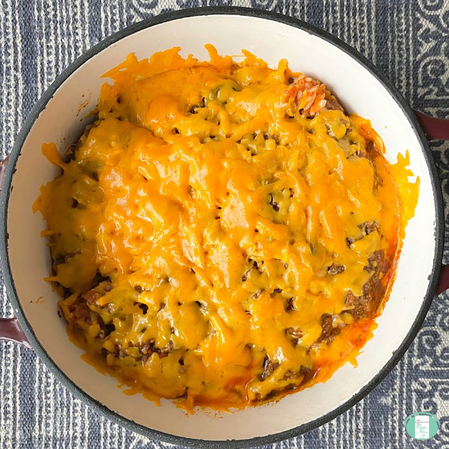 close up of Spanish rice casserole in a pot topped with cheese