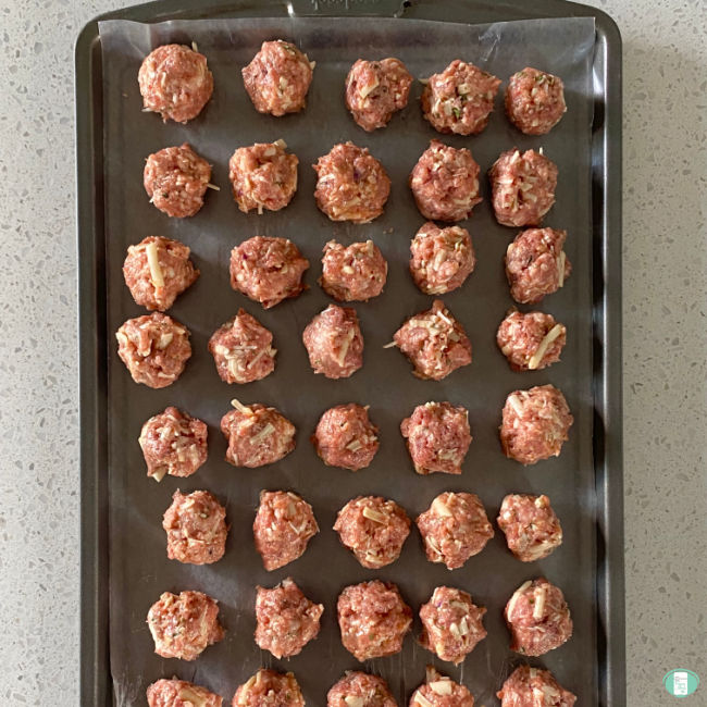 raw meatballs on a cookie sheet