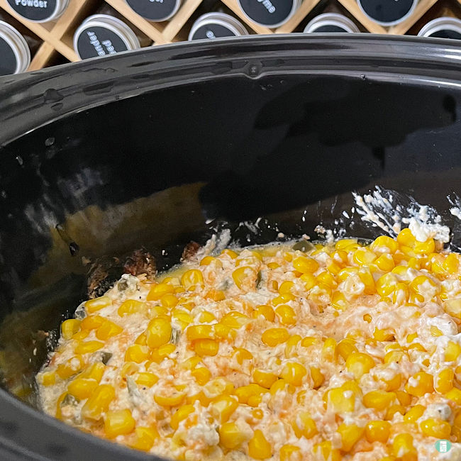 corn mixture in a black slow cooker
