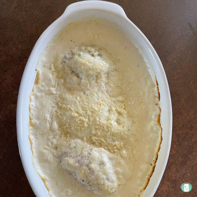 white casserole dish with chicken in a white cream sauce