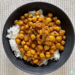 grey bowl with chickpea stew on top of rice