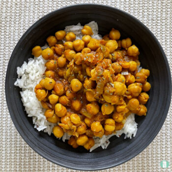 grey bowl with chickpea stew on top of rice