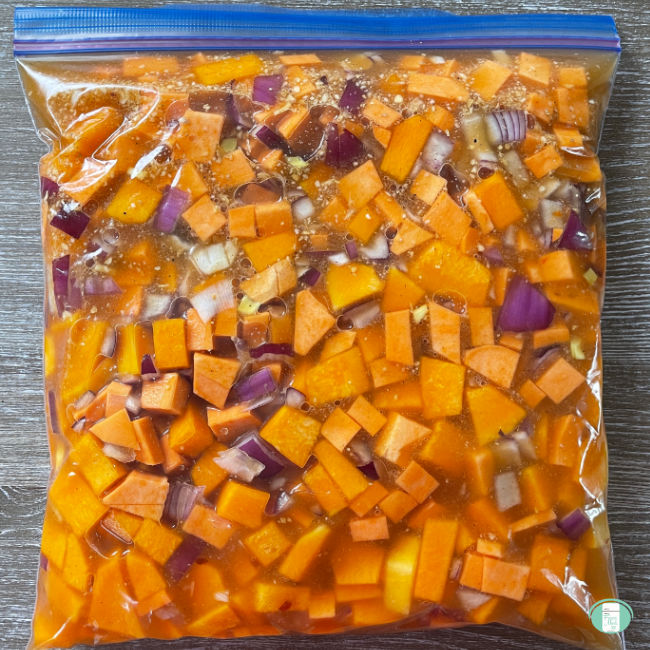 clear bag with cubed orange vegetables and purple onion