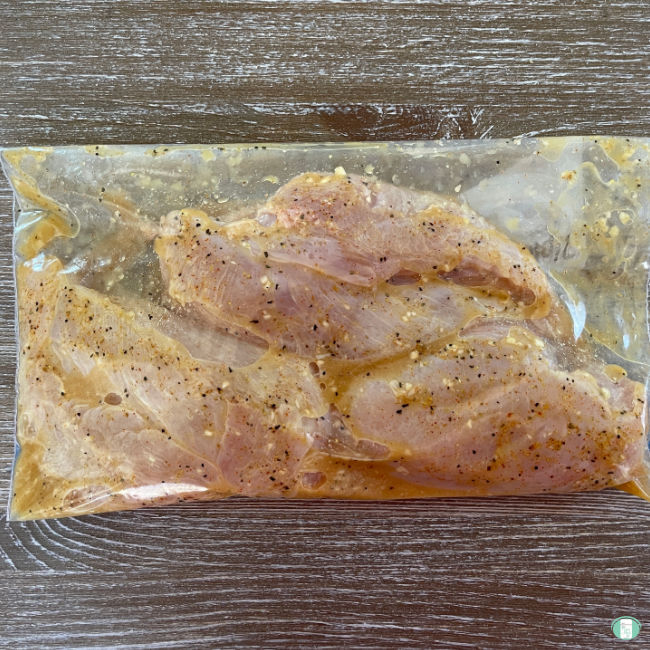 clear plastic bag with chicken marinating in it