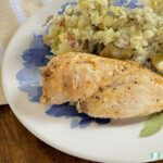 cooked chicken breast and potato salad on a plate
