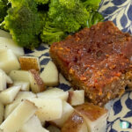 diced potatoes, broccoli, and a square of meatloaf on a plate
