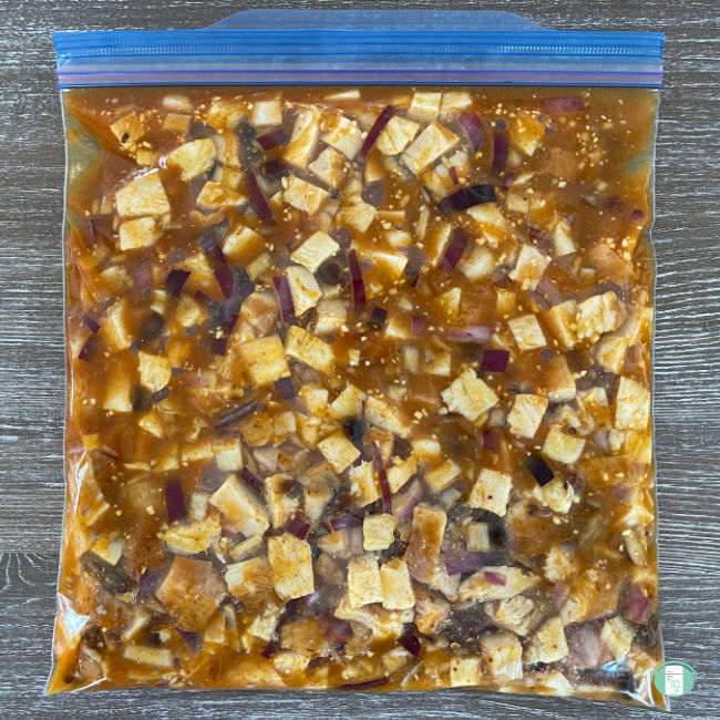 cubes of chicken and sauce in a clear bag