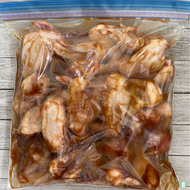 chicken wings coasted in sauce in a clear bag