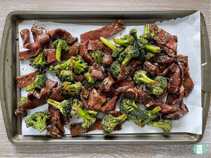 cookie sheet lined with parchment paper with beef and broccoli