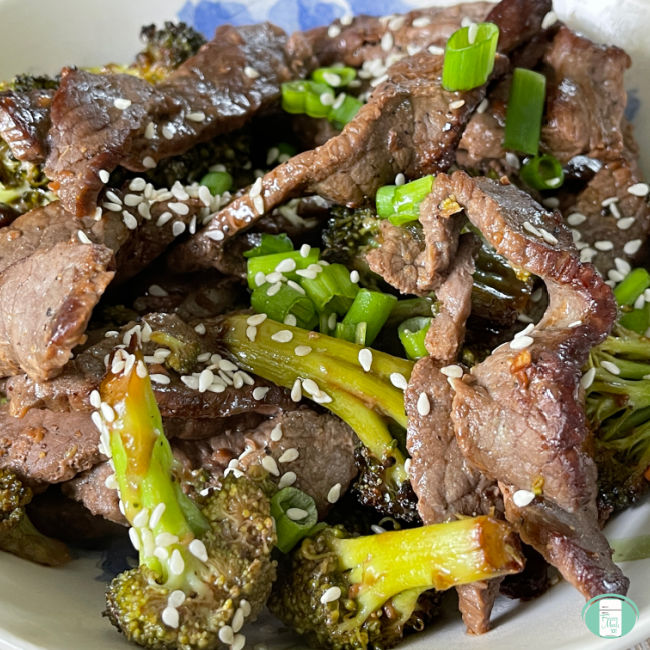 beef and broccoli sprinkled with sesame seeds and green onions