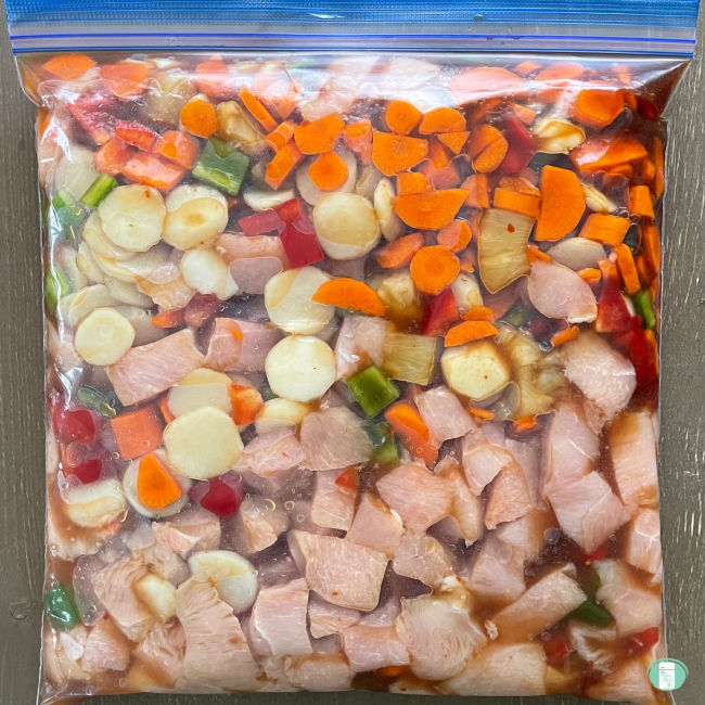 clear bag with vegetables, pineapple chunks, and cubed chicken