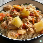 pineapple chunks, chicken, carrots, and rice in a bowl