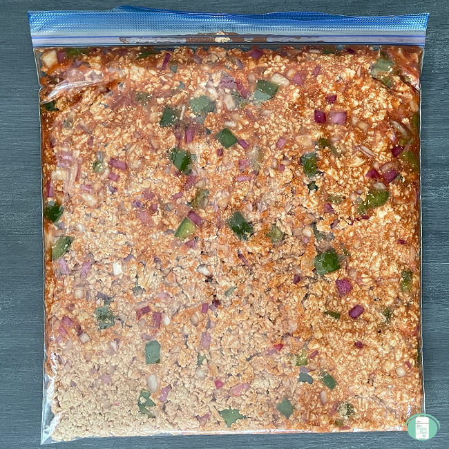 clear bag with a meat mixture in it with cubes of green pepper visible