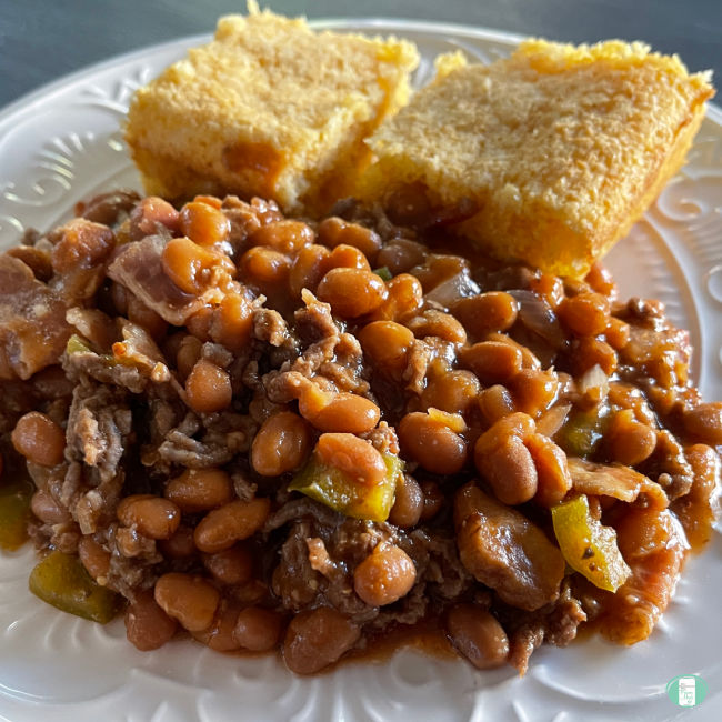 plate with large serving of beans next to two pieces of cornbread