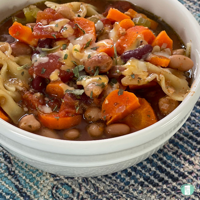 bowl of soup with vegetables and bowtie pasta