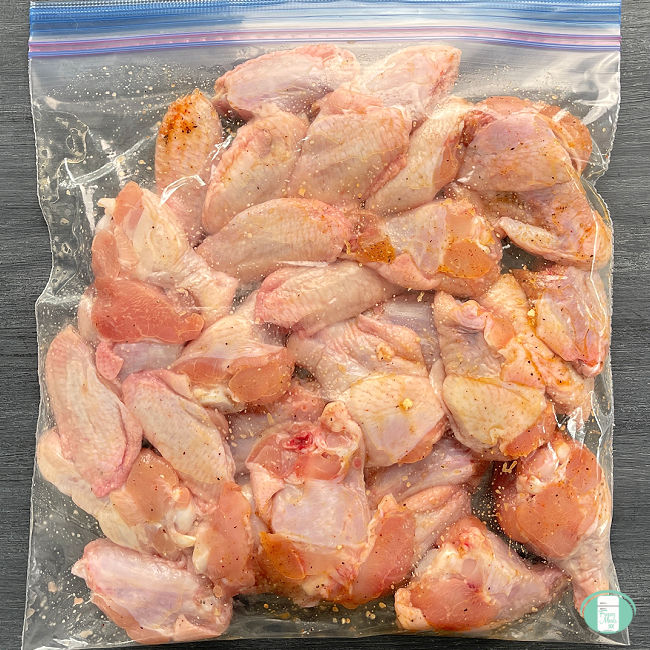 clear plastic bag filled with raw chicken wings