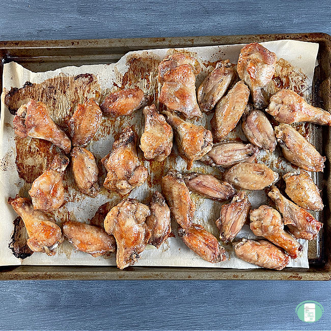 cooked chicken wings on a baking tray