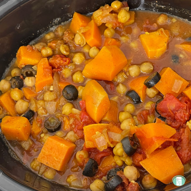 chickpea stew with cubes of sweet potatoes and black olives visible in slow cooker