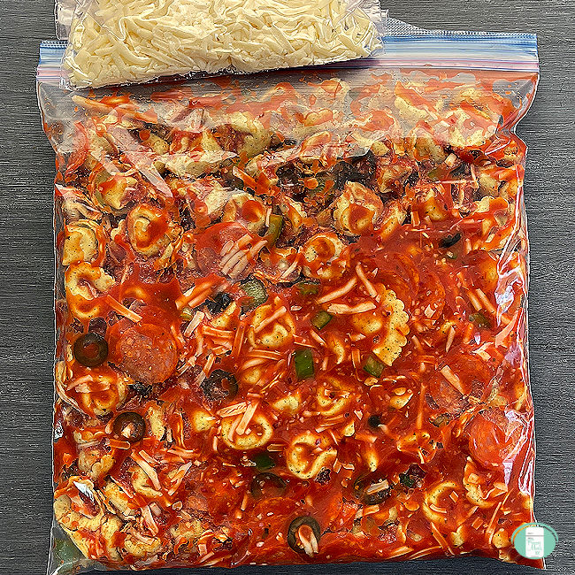clear bag with tortellini in red sauce and a bag of shredded white cheese