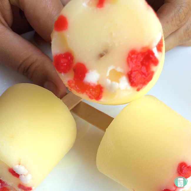 yellow frozen pudding on sticks with red and white sprinkles
