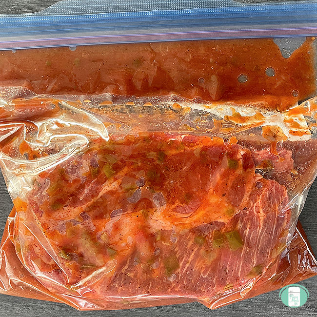 clear bag with beef roast in a sauce in it