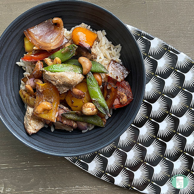 dark grey bowl with rice topped with chicken and vegetables