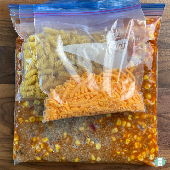 bag with ground beef and corn stapled to a bag with noodles and a bag with shredded cheese