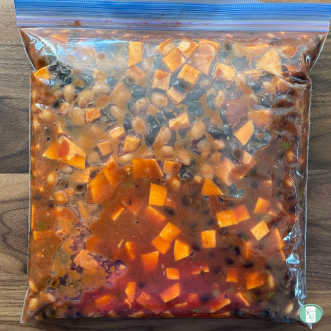 clear bag with beans, corn, and diced sweet potatoes in a tomato sauce