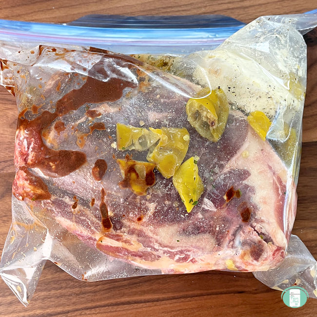 clear bag with a raw roast and peppers in sauce