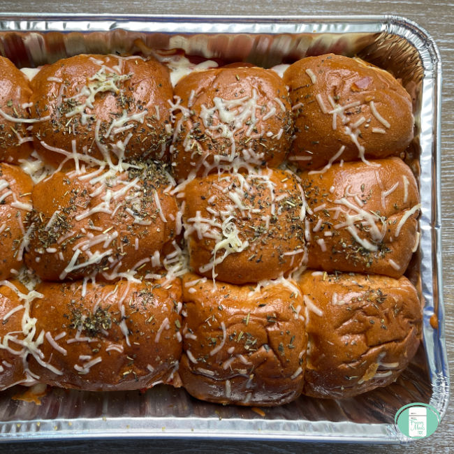 tray of buns topped with sprinkled cheese and seasonings