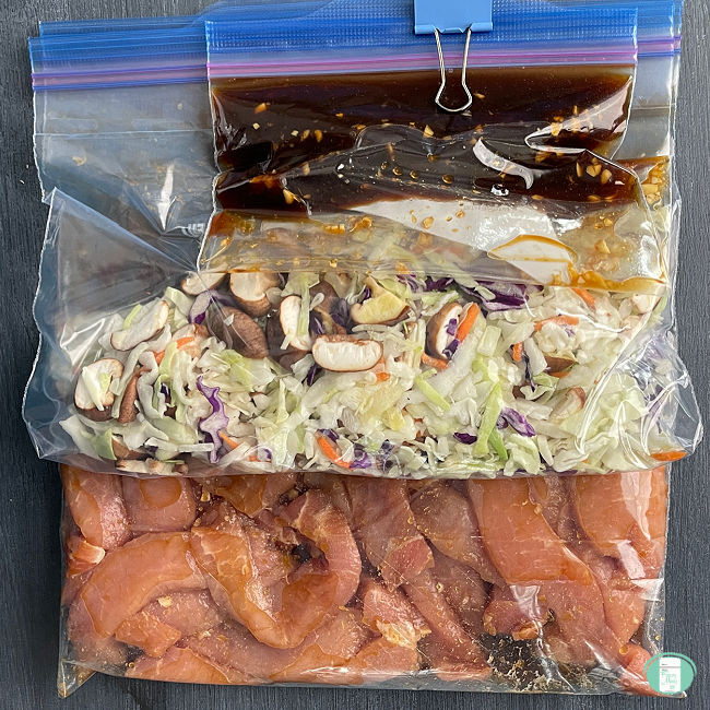 sliced pork, shredded cabbage, sliced mushrooms, and sauce in clear bags