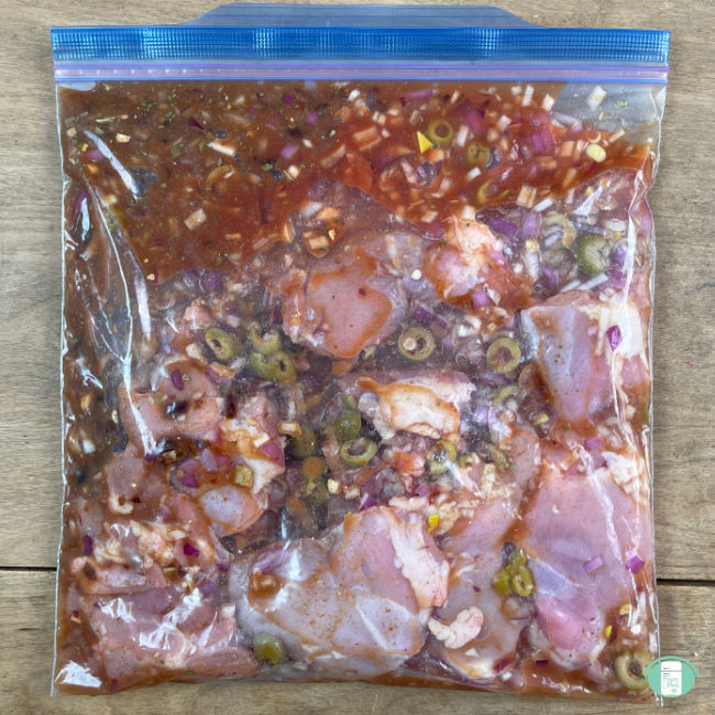 clear bag with raw chicken, olives, and seasonings