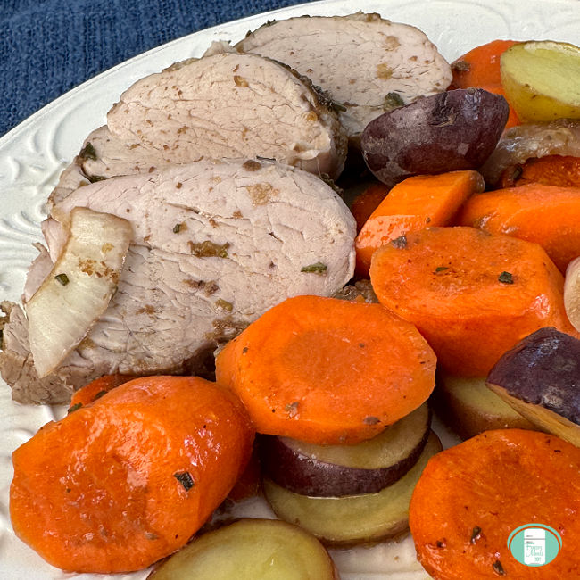 Close up of plate with sliced pork tenderloin, carrots, and potatoes.