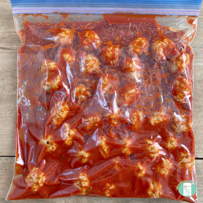 clear bag with meatballs in red sauce in it