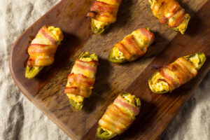 Overhead shot of several Bacon Wrapped Jalapenos on a charcuterie board