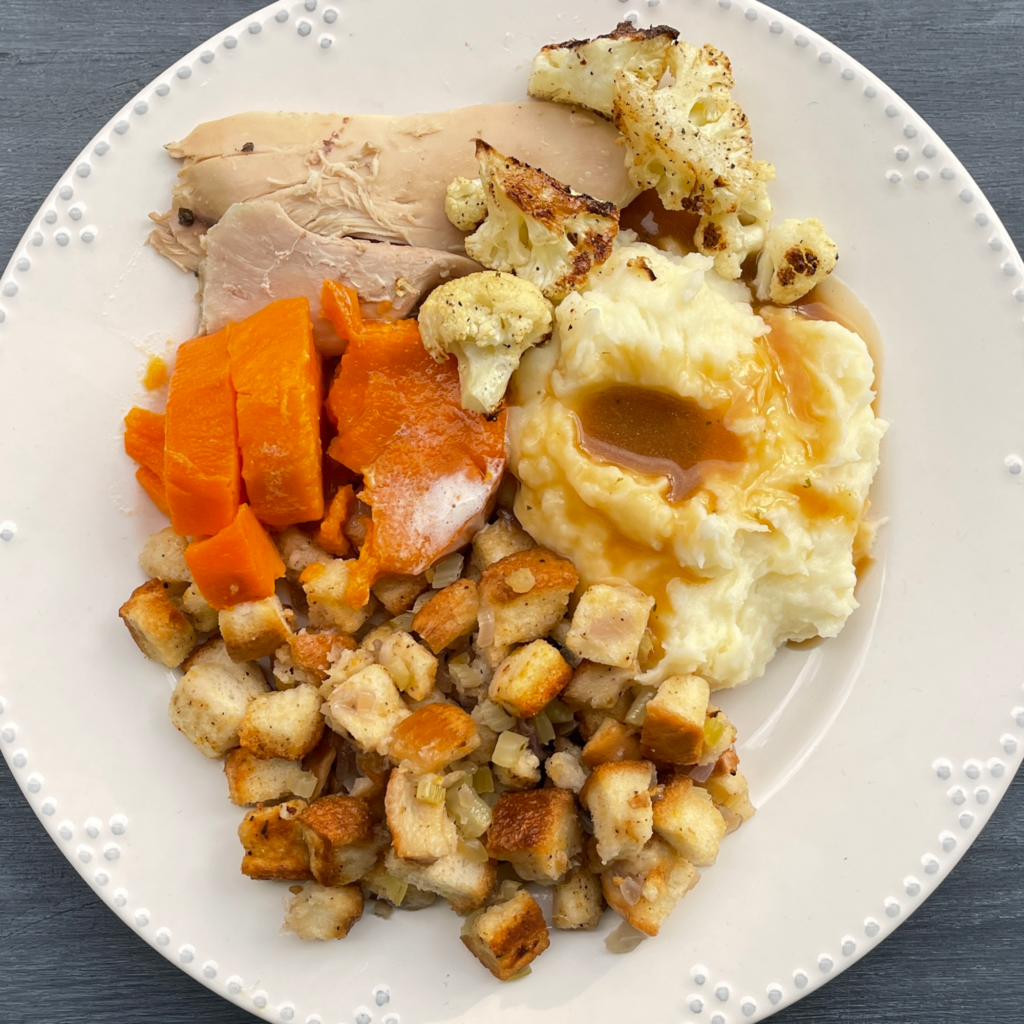 Overhead shot of Garlic Mashed Potatoes and Freezer Stuffing, served with gravy, carrots and turkey