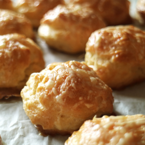 up close shot of Gougères on a baking sheet, they are puffy and toasted