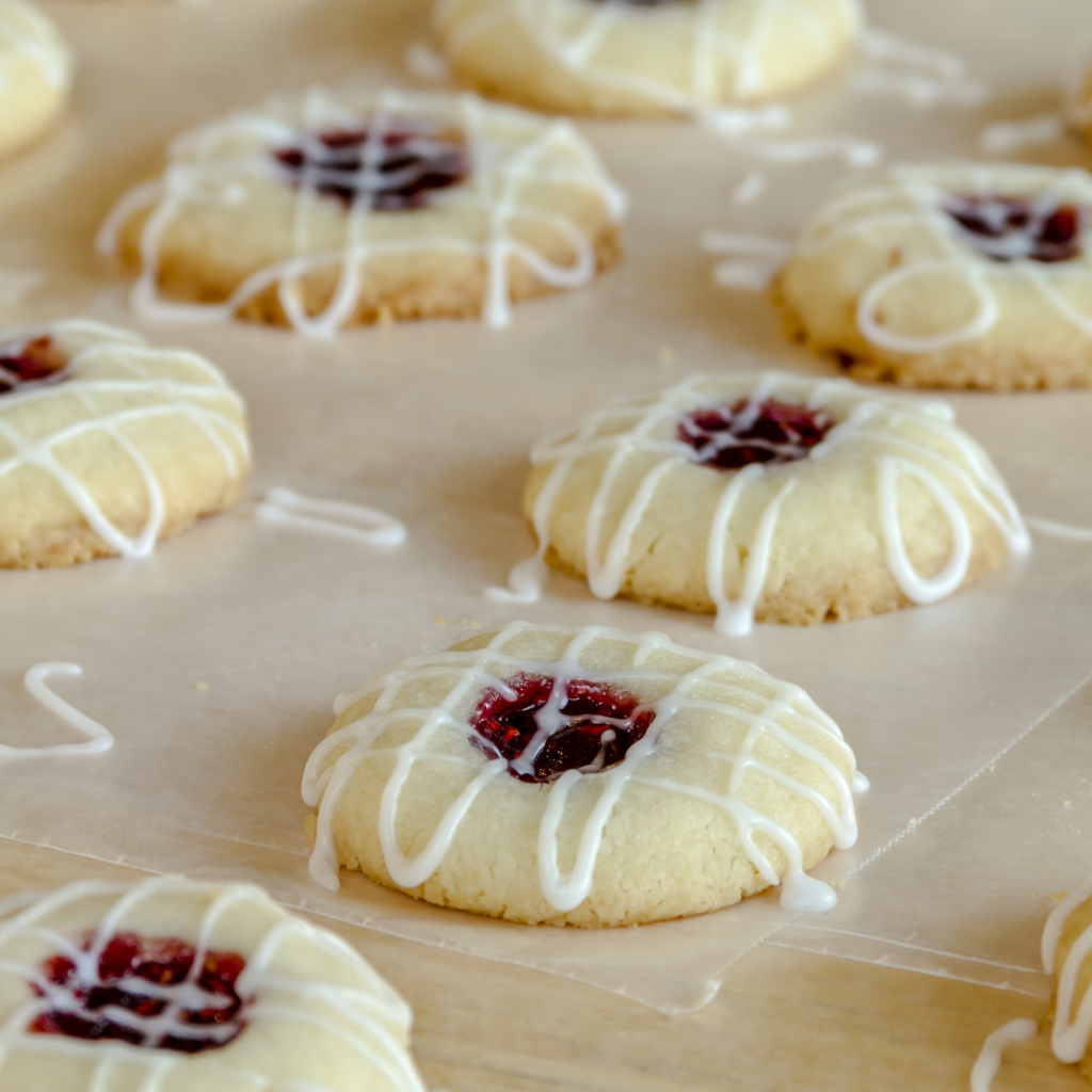 Raspberry Almond Thumbprint Cookies with an icing drizzle criss-crossing the cookies