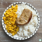 Chili Lime Pork Chops on a black and white plate with corn and rice.