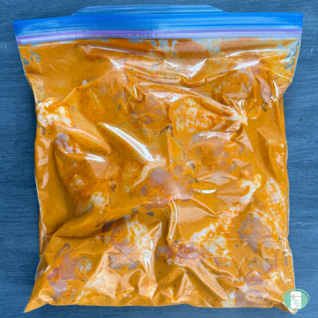 All of the ingredients for Doro Wat are pictured in a freezer meal bag except for the boiled eggs.