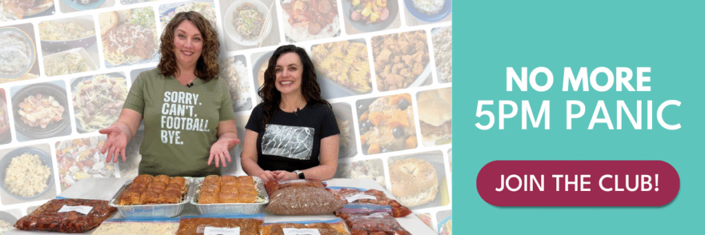 two women with a counter full of freezer meals in front of them