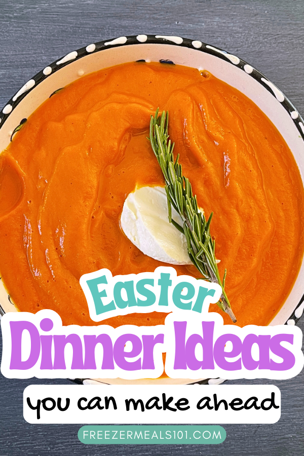 bowl of orange soup topped with a dollop of sour cream and a sprig of rosemary